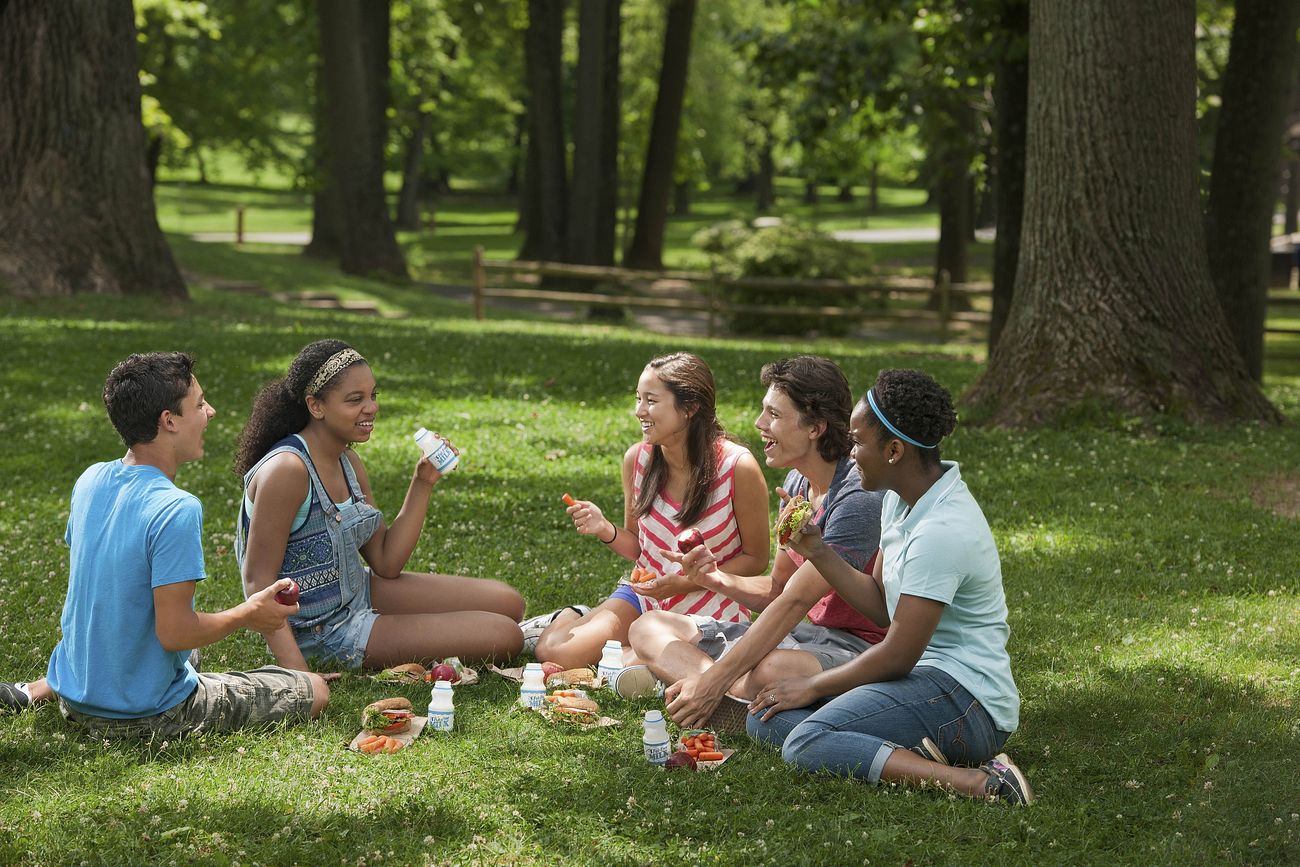 Teens eating at a park in summer